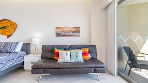 A modern living room with a sofa, a side table, and a painting on the wall.