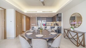 A modern dining area with a round table set for four, surrounded by cushioned chairs.