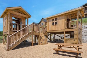 Wooden play structures with a picnic table. - Table Rock View Log Cabin with Private Hot Tub, Firepit, Lake Access & Free Attraction Tickets (Branson)