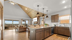 Una cocina amplia con una isla grande, armarios de madera e iluminación colgante.