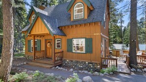 Une cabane en bois avec un porche, des fondations en pierre et le numéro 4295.