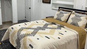 Una camera da letto ordinata con un letto, un armadio e una scaffalatura.