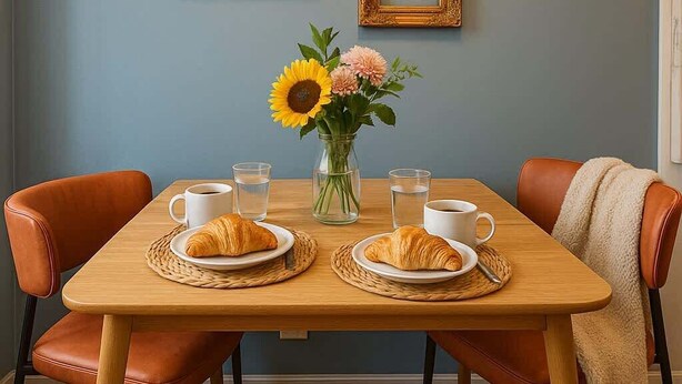 A dining table with two chairs, a vase with flowers, and two framed pictures on the wall. - Sleeps 5  Peaceful  King Bd  Walk Score 98 (Philadelphia)