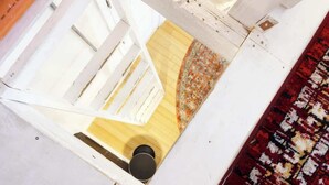 A room with a wooden floor, a patterned rug, and a white wall. - Sleeps 5  Peaceful  King Bd  Walk Score 98 (Philadelphia)