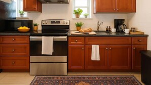 A kitchen with wooden cabinets, a stainless steel oven, a microwave, and a coffee maker. - Sleeps 5  Peaceful  King Bd  Walk Score 98 (Philadelphia)