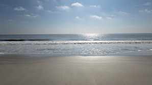 Una playa con cielo despejado y mar tranquilo.