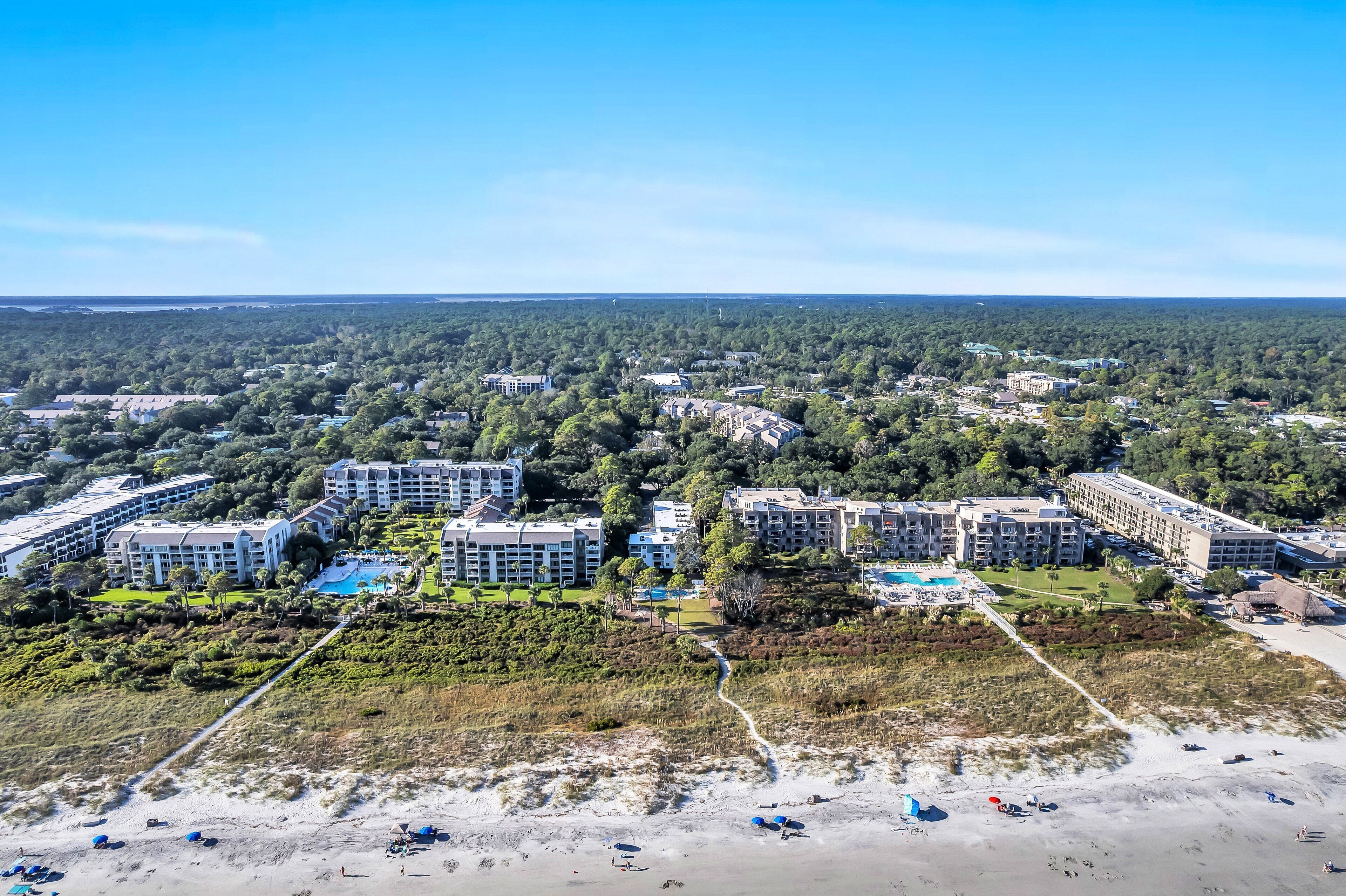 A coastal resort with multiple hotel buildings, a beach, and a golf course.
