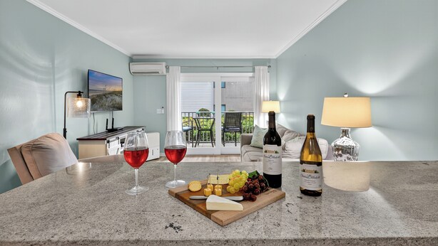 Comedor con una mesa dispuesta para una comida, incluyendo queso, uvas y una botella de vino.
