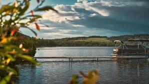 A lake with a dock and a boat house. - L'étoile du lac Lyster (Coaticook)