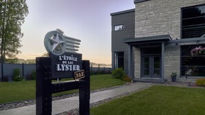 A modern building with a sign indicating 'L'ETOILE DU LAC LYSTER' and a B&B logo. - L'étoile du lac Lyster (Coaticook)