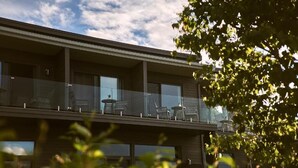 A modern building with a balcony featuring outdoor seating. - L'étoile du lac Lyster (Coaticook)
