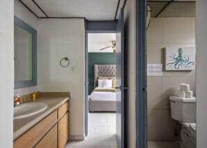 A modern bathroom with a sink, toilet, and a mirror.