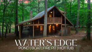 A cabin with a porch, a fire pit, and a hot tub. - Pondside Woodland Escape for Families and Friends (Broken Bow)