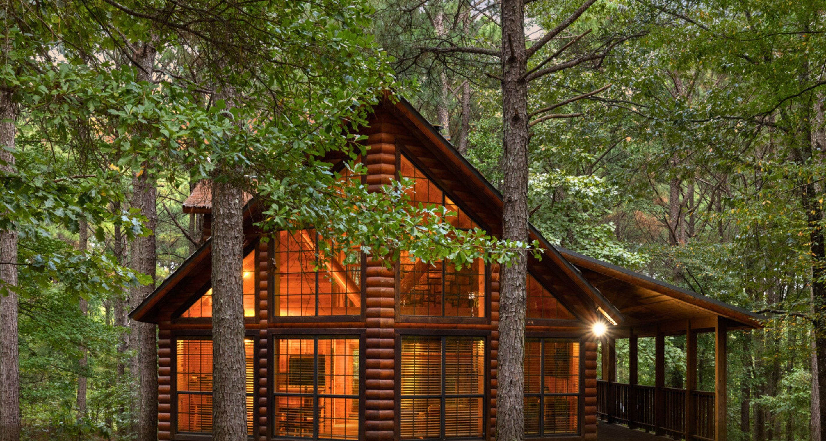 A log cabin with a wooden exterior, surrounded by trees.