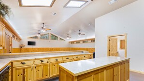 Une cuisine spacieuse avec des meubles en bois, un îlot central et des fenêtres de toit.