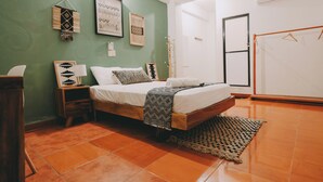 A bedroom with a bed, a nightstand, a wall-mounted shelf, and a door. - Hotel Posada Girasol (Puerto Escondido)