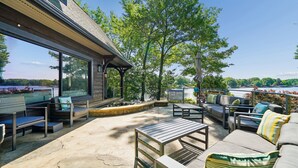 An outdoor patio with seating, a table, and a view of a body of water.