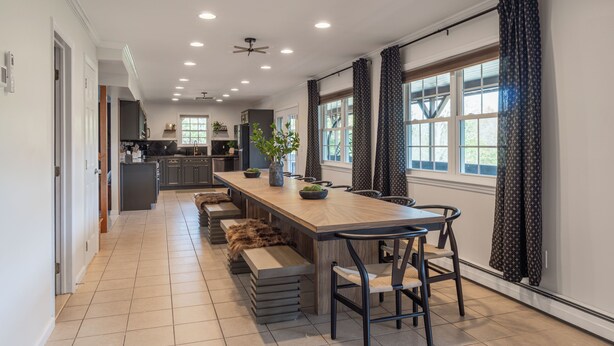A modern kitchen with a long island, built-in appliances, and a dining area with a bench seating arrangement. - NEW LISTING! Heated Pool + Sauna + Hot Tub + Game Room + Jungle Gym + Fire Pit (Windham)