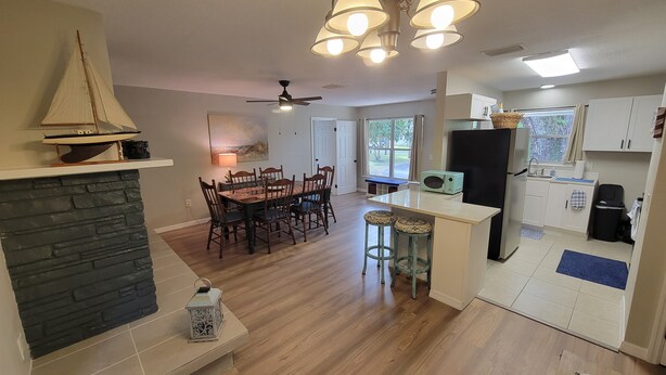 A spacious kitchen with a central island, a dining area with a large table, and a fireplace. - 3 Bed/2 Bath Cottage near downtown  Crystal River (Crystal River)