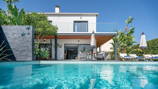 A modern house with a swimming pool, a covered patio, and outdoor seating. - Stylish Algarve Retreat- Priv. Pool & Beach Nearby (Quarteira)
