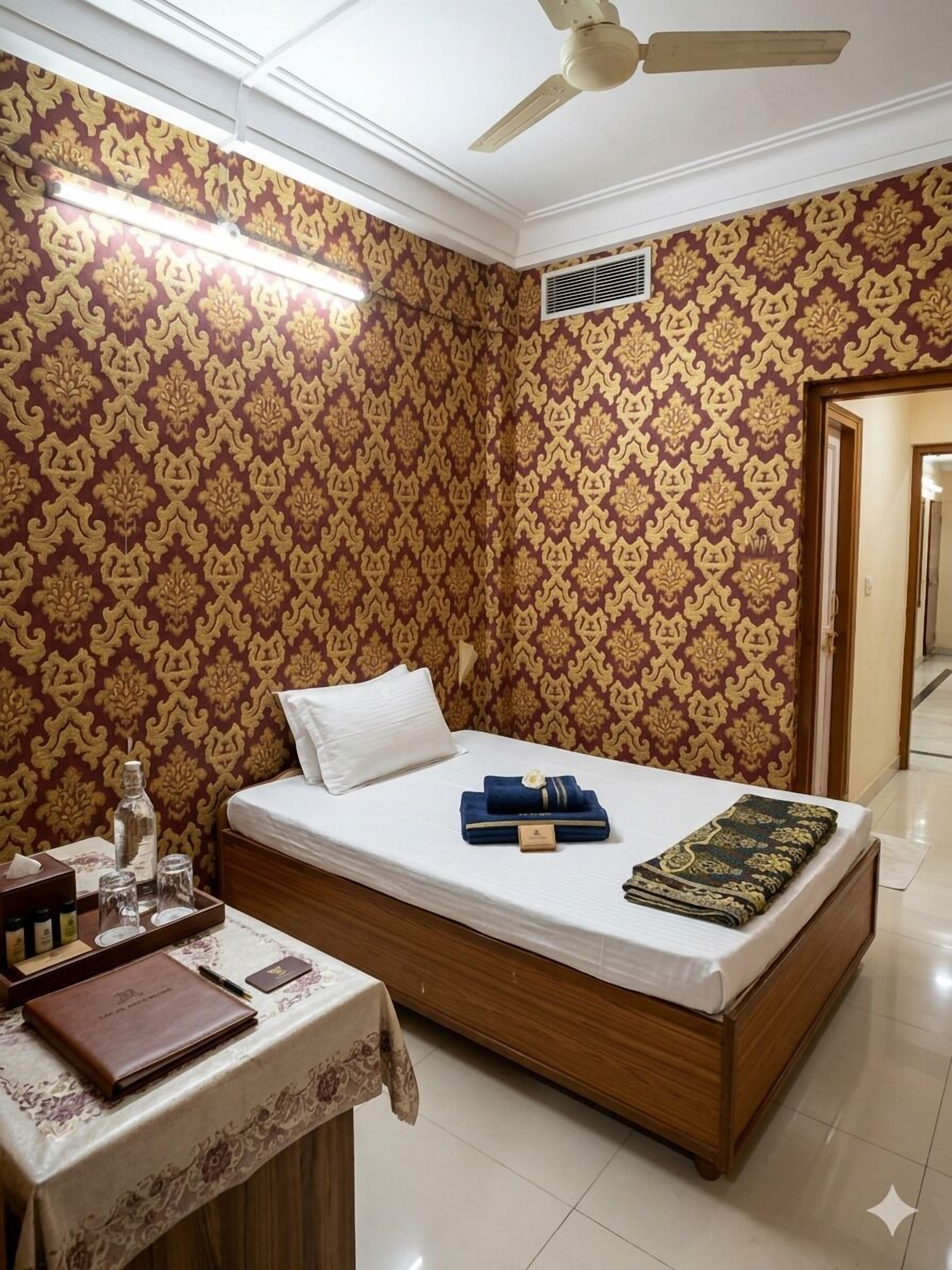 A bedroom with a bed, bedside table, and a ceiling fan.