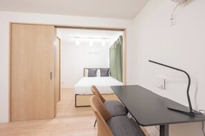 A modern room with a bed, a desk, and a chair. - MAT Nogata (Tokyo)