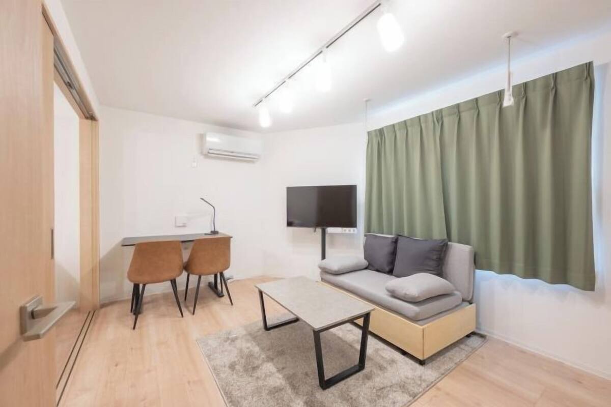 A modern living room with a sofa, a coffee table, and a TV.