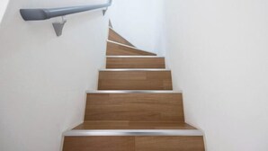 A staircase with wooden steps and a metal handrail. - MAT Nogata (Tokyo)