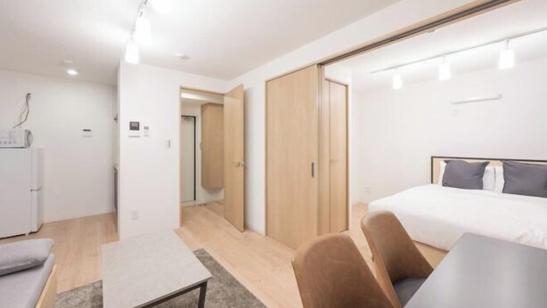 A modern hotel room with a bed, a desk, a chair, and a wardrobe. - MAT Nogata (Tokyo)