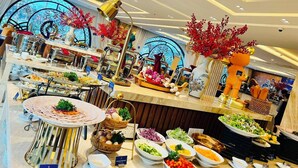 A buffet setup with various food stations, including cold cuts, salads, and vegetables. - Sandals Vista (1 Bao Loc)
