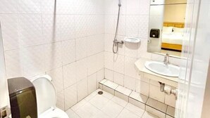 A small, clean bathroom with a toilet, a shower, and a sink. - ABCYQ Hotel (Bangkok)
