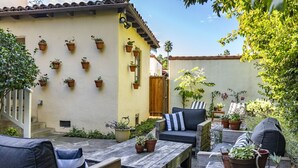 A patio area with outdoor seating, potted plants, and a staircase leading to an upper level. - Enjoy indoor-outdoor living, full kitchens and walk to beach and state st. (Santa Barbara)