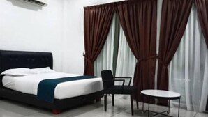 Una camera d'albergo con un letto, una sedia, un tavolino e tende.