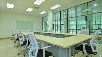 A conference room with a long table, chairs, and large windows.