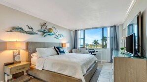 Une chambre d’hôtel moderne avec un grand lit, un bureau et une télévision.
