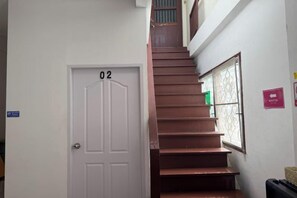 A staircase leading to a door marked with the number 02, a window with a decorative grille, and a sign indicating a 'Restroom' on the wall. - Sleep Break Hostel Sathon (Bangkok)