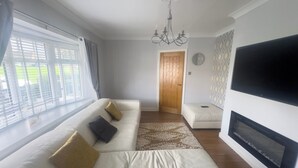 Una sala de estar moderna con un sofá, un televisor y una chimenea.