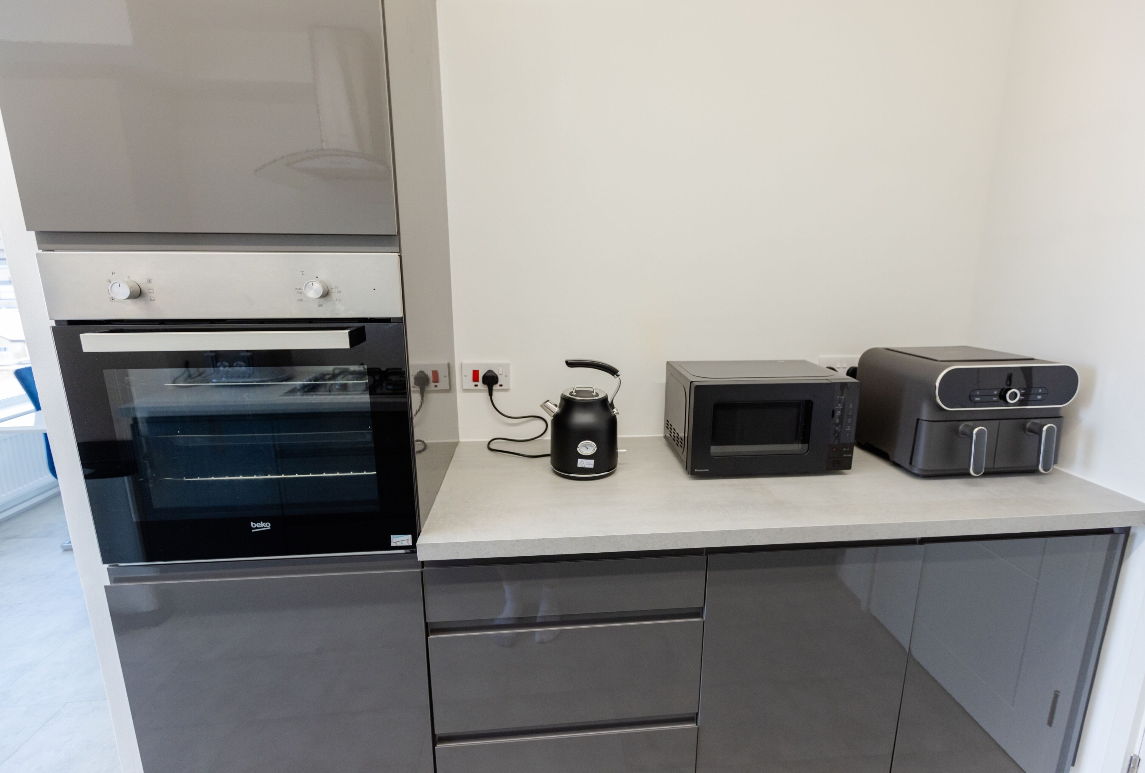 A kitchenette with a built-in oven, a microwave, and a toaster.