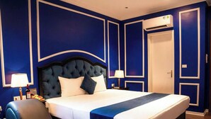 Une chambre d’hôtel avec un grand lit, deux tables de chevet, une chaise et une porte.