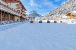 A snow-covered hotel courtyard with a mountain in the background. - l'Ours Bleu B13 Ski-In at Vallorcine| Shared Pool, Gym & Wellness, Vallorcine (Argentiere), France (Vallorcine (Argentiere))