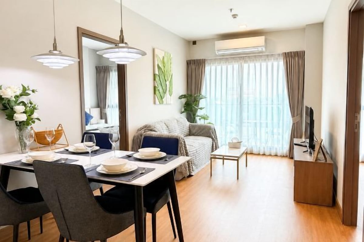 Ein modernes Wohnzimmer mit Essbereich, einer Couch und einem Fernseher.