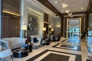 A spacious lobby with a marble floor, modern furniture, and a large decorative mirror. - Astra Sky River Infinity Pool Sky City Apartment (Chiang Mai)