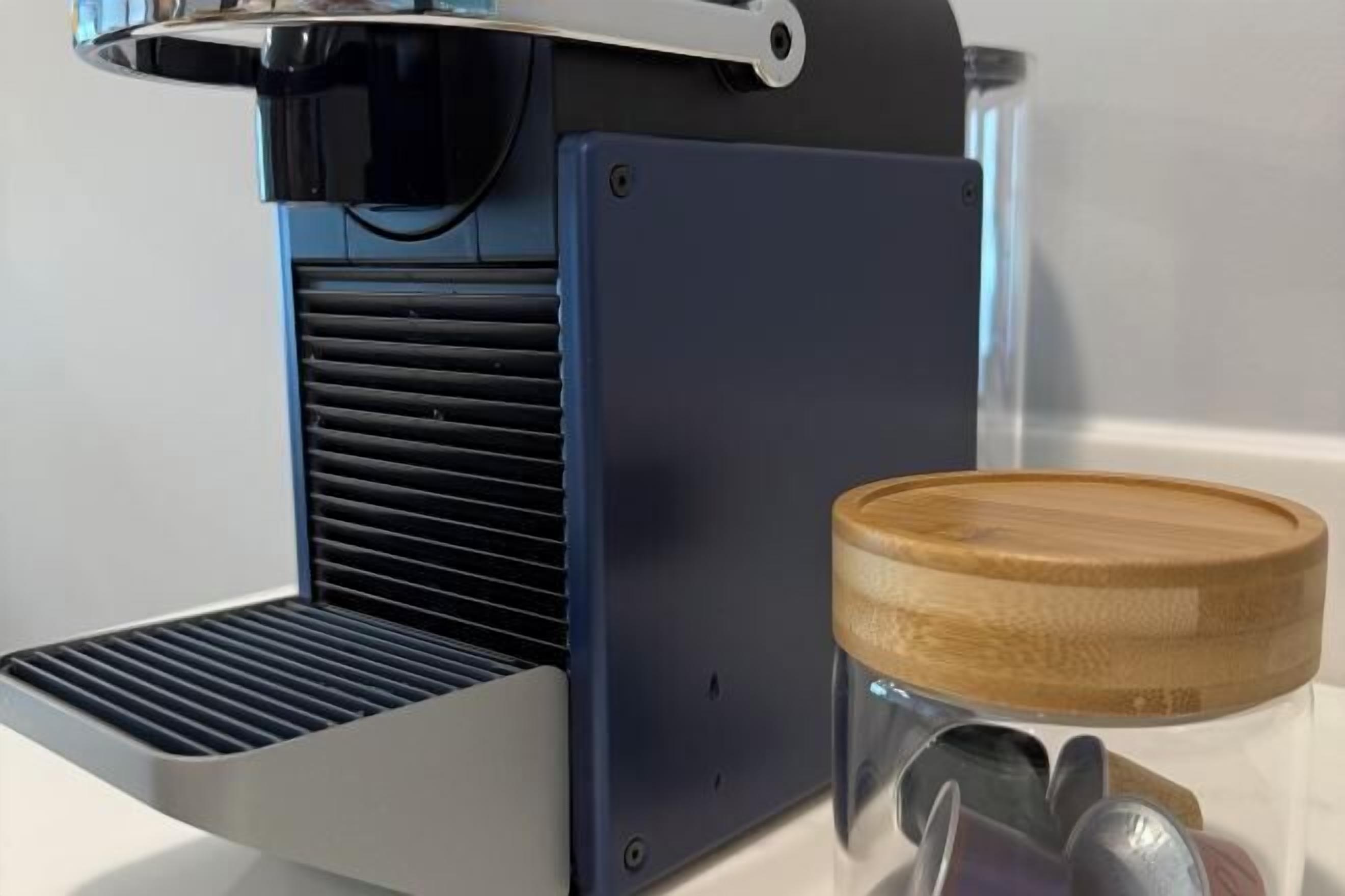 Une machine à café avec un récipient en bois à côté.