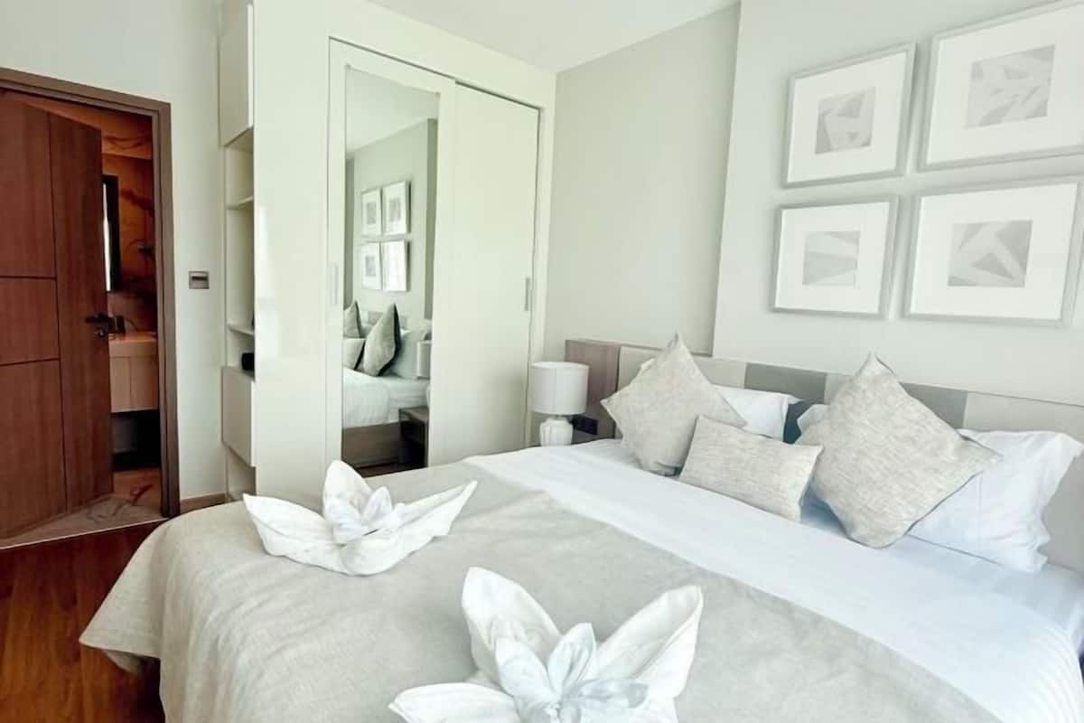 A hotel room with a bed, a wardrobe, and a mirror.