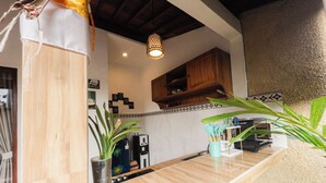 Une cuisine avec des meubles en bois, un plan de travail en marbre et un luminaire suspendu.