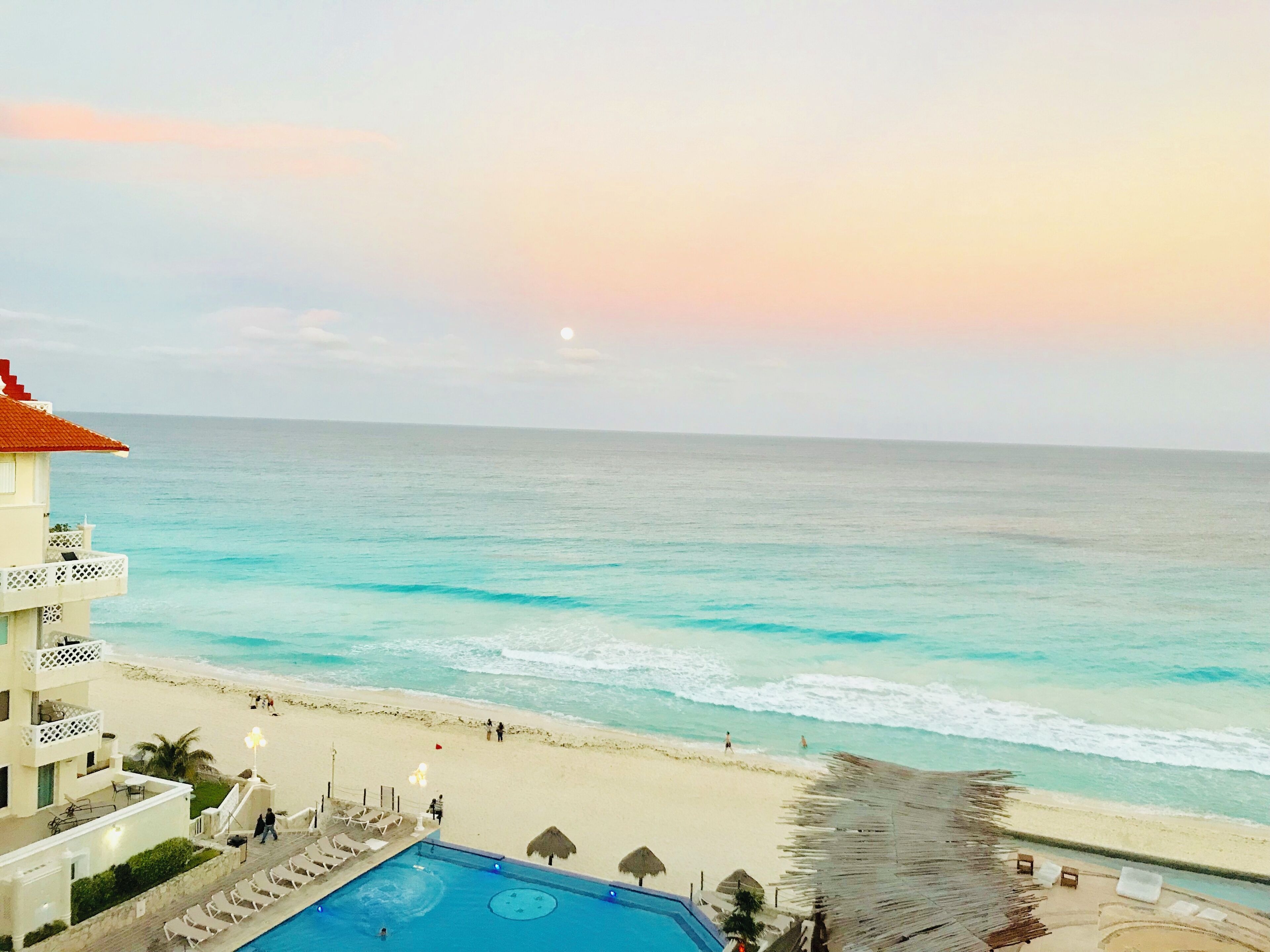A beachfront hotel with a swimming pool, beach access, and ocean views.