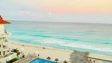 A beachfront hotel with a swimming pool, beach access, and ocean views.