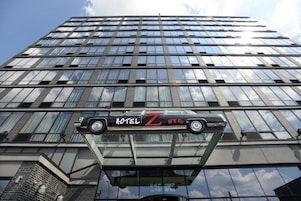 Ein Hochhaus mit einer großen Glasfassade und einem darin schwebenden Auto.