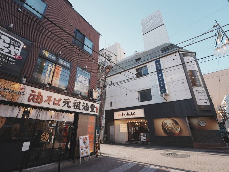 A building with multiple signs, including one for a hotel and another for a restaurant.