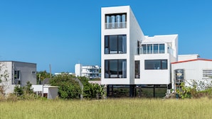 A modern two-story building with large windows, a balcony, and a flat roof. - Unknown Coffee Inn (Liuqiu)